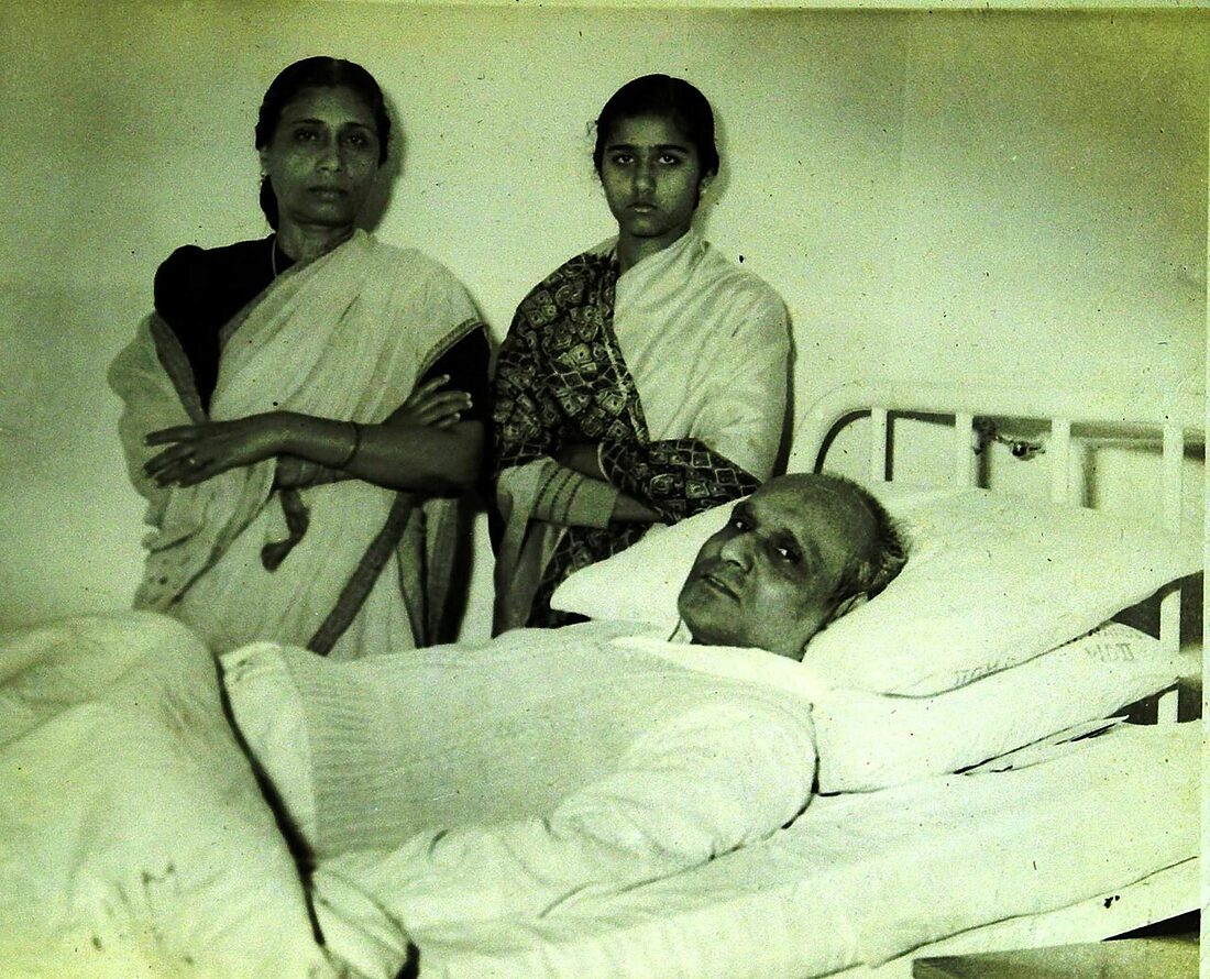 Batukeshwar Dutt lying in a hospital bed during his final illness, with his wife Anjali and daughter Bharati standing beside him.