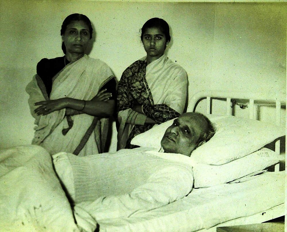 Batukeshwar Dutt in a hospital bed during his final illness, with his wife and daughter standing beside him.
